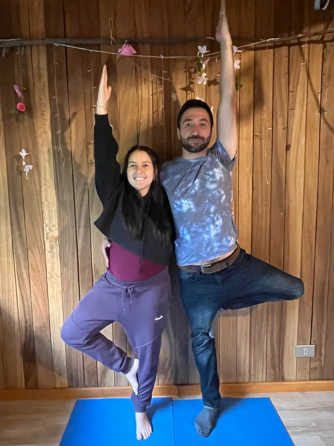 Pareja realizando postura de yoga en conjunto
