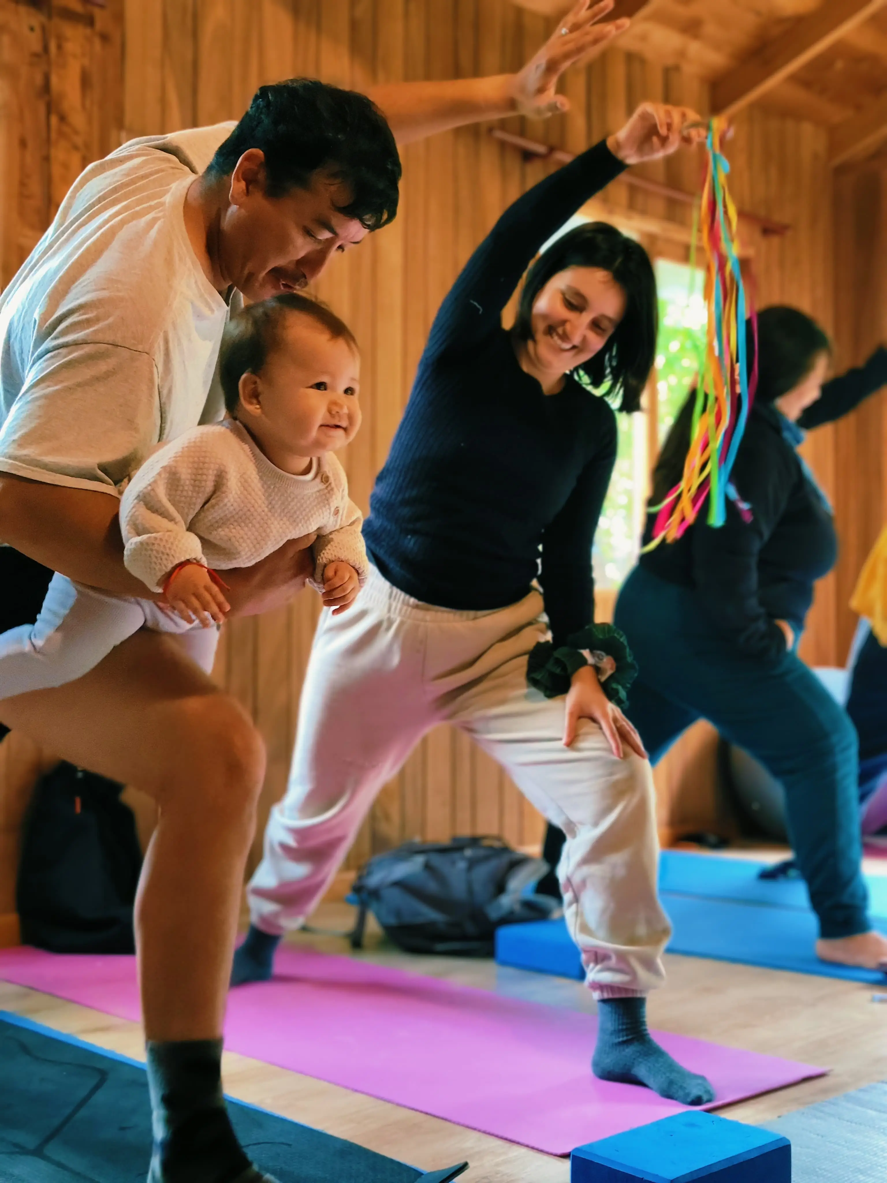 Mujer realizando postura de yoga con bebé