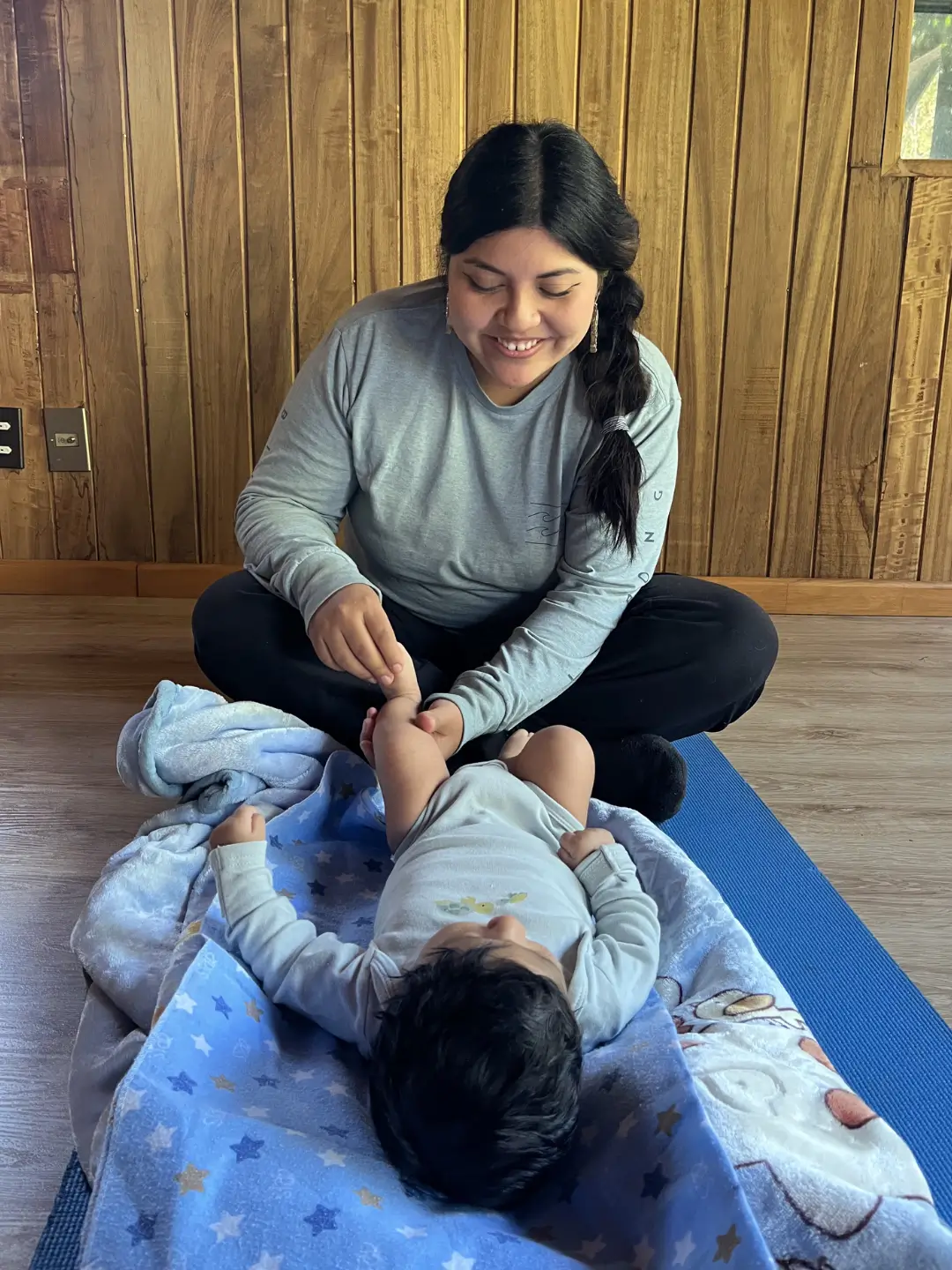 Mujer realizando postura de yoga con bebé